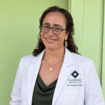 Dr. Rachel Robitz in front of a green wall.